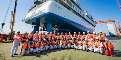 Shipyard workers gathered around the 'Greg Mortimer'.