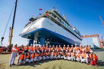 Shipyard workers gathered around the 'Greg Mortimer'.