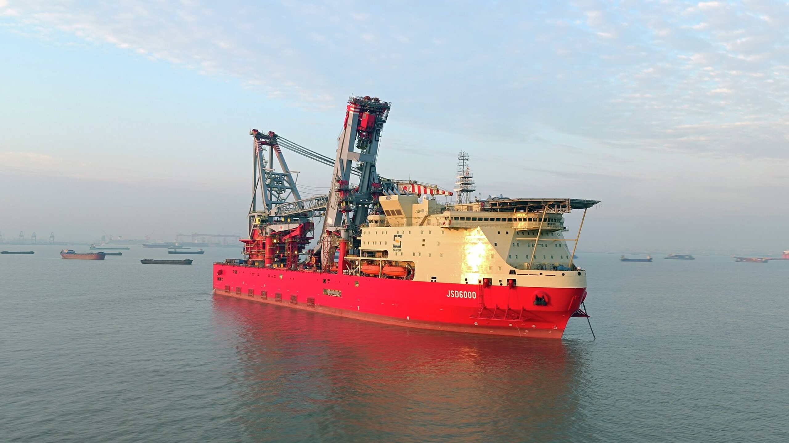 The heavy lift pipelay vessel, ‘JSD 6000’, is a customised ULSTEIN SOC5000 design. The 215m long DP3 vessel is equipped with a 5,000t revolving main crane and will be cable of performing J-lay and S-lay pipelay work in max water depths of 3,000m.. The combination of heavy lift and S-Lay capabilities together with J-Lay functionality via a large, off-centre moonpool, allows the vessel to serve deepwater and SURF markets as well as shallow-water EPCI projects.  The JSD 6000 vessel is the third cus